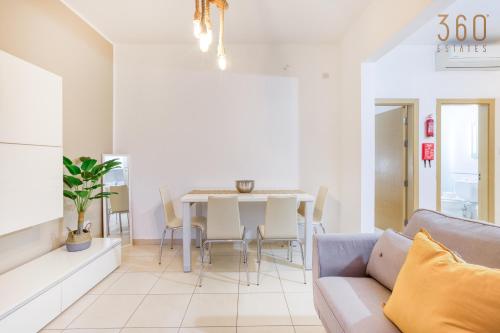 a living room with a couch and a table at Modern 1BR home with Private Balcony in St Julians by 360 Estates in Tal-Għoqod