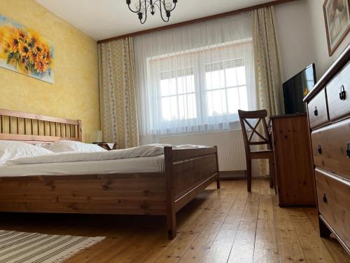 sypialnia z łóżkiem, krzesłem i oknem w obiekcie Landgasthof Faymann 