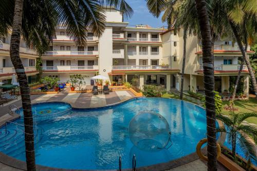 uma vista sobre a piscina do resort com palmeiras em Sterling Goa Varca em Varca