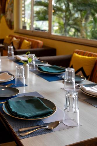 una mesa con platos verdes y cubiertos en Sterling Goa Varca, en Varca