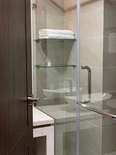 a bathroom with a glass shower stall with towels at Bờ Biển Vàng Resort in Ke Ga