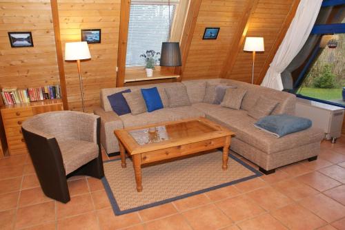 a living room with a couch and a coffee table at Zeltdachhaus mit Kamin und grosser Terrasse in Damp