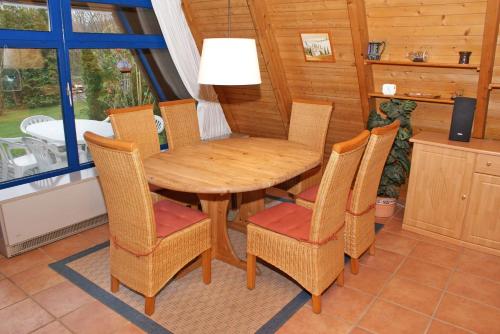 a dining room with a wooden table and chairs at Zeltdachhaus mit Kamin und grosser Terrasse in Damp