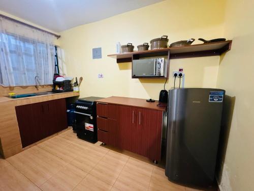 Il comprend une cuisine équipée d'un réfrigérateur et d'un comptoir. dans l'établissement Lovely 2 Bedroom Apartment in Ongata Rongai, à Langata Rongai