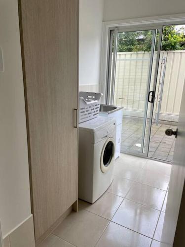 a washing machine in a room with a door at Sofia’s Place in Aldinga Beach