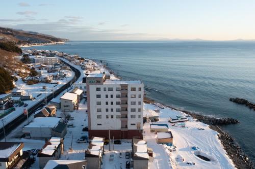 an aerial view of a beach with buildings and the water at LiVEMAX RESORT Shiretoko Sea Front in Rausu