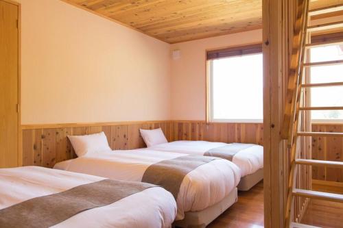 a row of four beds in a room at Wind and horn Private villa with Mt tanigawa view 