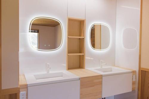 a bathroom with two sinks and two mirrors at Wind and horn Private villa with Mt tanigawa view in Komatsu