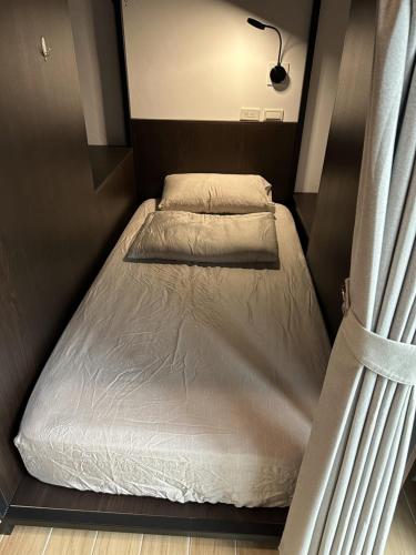 a small bed in a small room with at Oceans Explore Hostel in Green Island