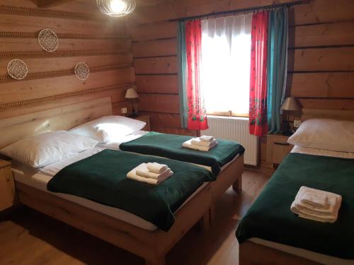 two twin beds in a room with a window at Pokoje Gościnne Iwona in Brzegi