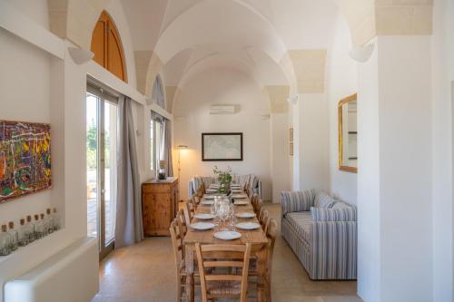 a dining room with a long table and chairs at Masseria Casina Baronale in Serrano