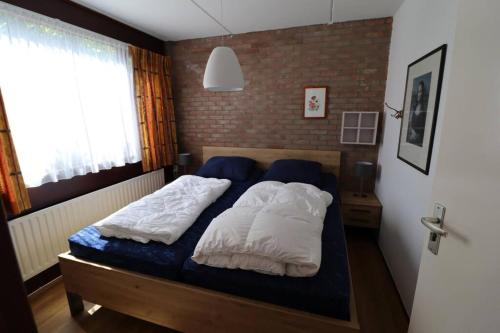 um quarto com uma cama com duas almofadas em Lepelblad 37* em Nieuwvliet