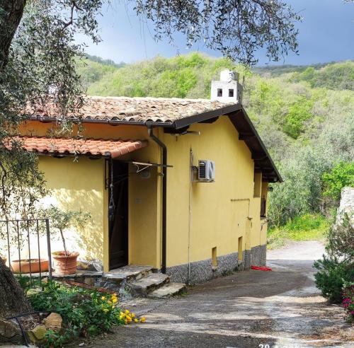 een klein geel huis met een heuvel op de achtergrond bij Villa Berio Tre - Kelan in Villa Viani