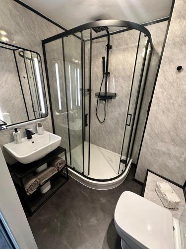 a bathroom with a shower and a toilet and a sink at Sporting Lodge Inn Middlesbrough in Middlesbrough