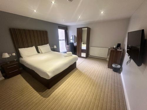 a hotel room with a bed and a television at Sporting Lodge Inn Middlesbrough in Middlesbrough