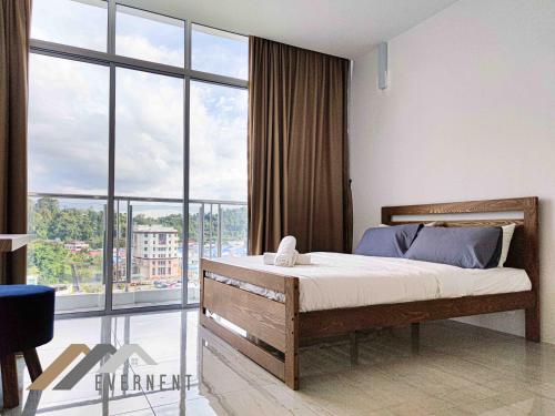 a bedroom with a bed and a large window at Stirling Suites by Evernent in Miri