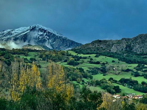 a snow covered mountain in the middle of a valley at Apartamentos Rurales & Spa La Bárcena in Enterria