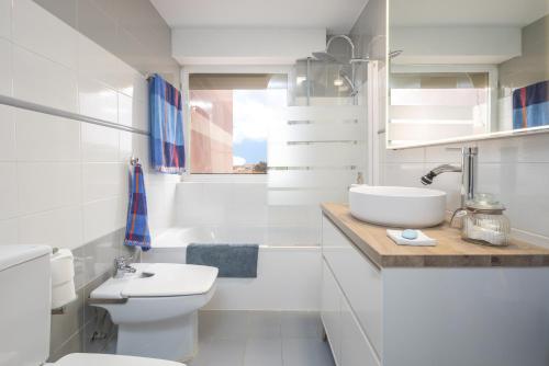 a white bathroom with a sink and a toilet at Casa Ibicenca in S'agaro