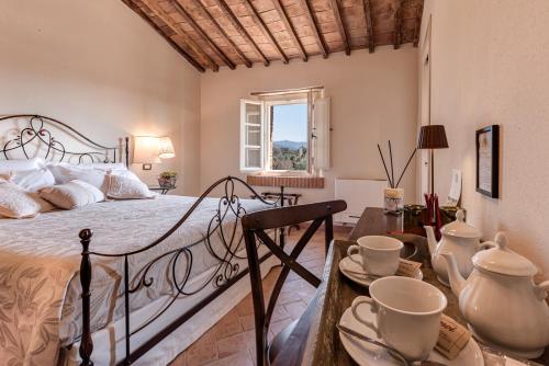 a bedroom with a bed and a table with cups on it at Locanda dell'Aioncino in Bibbona