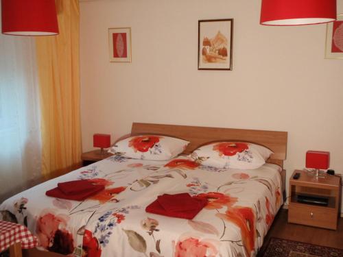 a bedroom with a bed with red flowers on it at Sobe Vera in Bovec