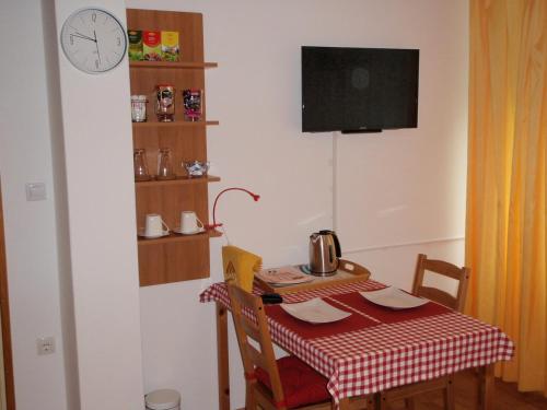 a small kitchen with a table and a clock on the wall at Sobe Vera in Bovec