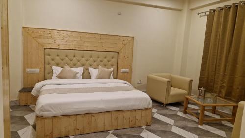 um quarto com uma cama grande e uma cadeira em Red House Cafe & Inn em Jibhi