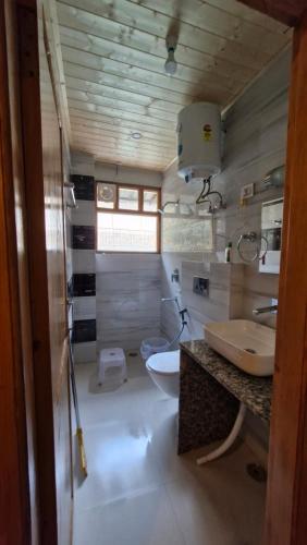 uma casa de banho com uma banheira, um lavatório e um WC. em Red House Cafe & Inn em Jibhi