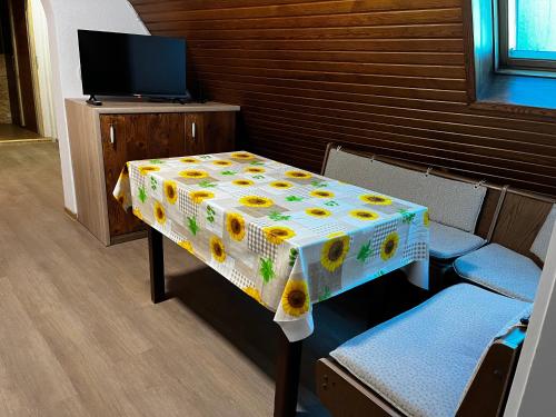 a table with a flowered table cloth on it with two chairs at Casa Veli Apartments in Offenburg