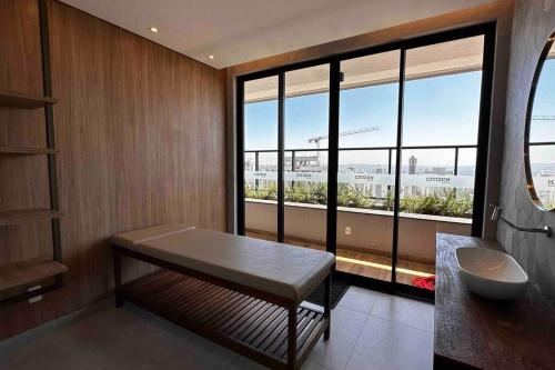 uma casa de banho com um lavatório e uma grande janela em Apartamento 2 quartos, St Bueno Parque Vaca Brava em Goiânia