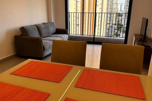 a living room with a table and two orange mats at Apartamento 2 quartos, St Bueno Parque Vaca Brava in Goiânia
