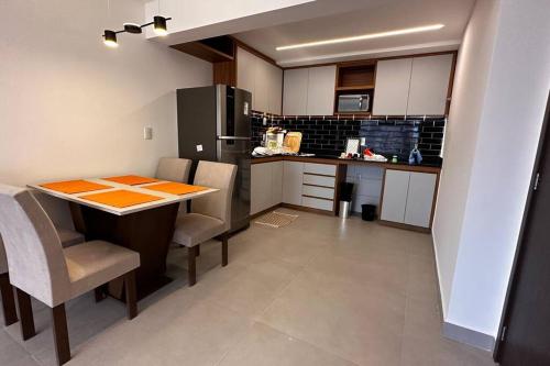 a kitchen with a table and some chairs and a counter at Apartamento 2 quartos, St Bueno Parque Vaca Brava in Goiânia