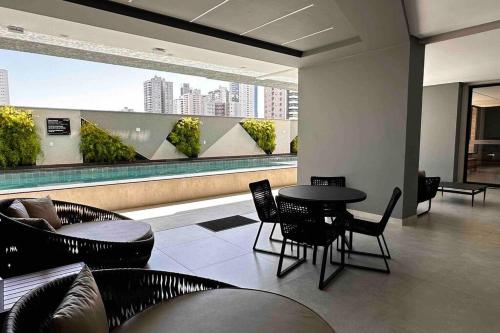 Apartamento 2 quartos, St Bueno Parque Vaca Brava في غويانيا: غرفة مع طاولة وكراسي في مبنى