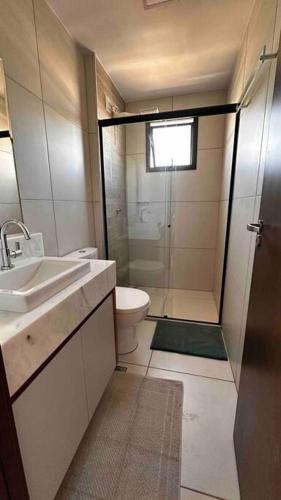 a bathroom with a shower and a sink and a toilet at Apartamento 2 quartos, St Bueno Parque Vaca Brava in Goiânia