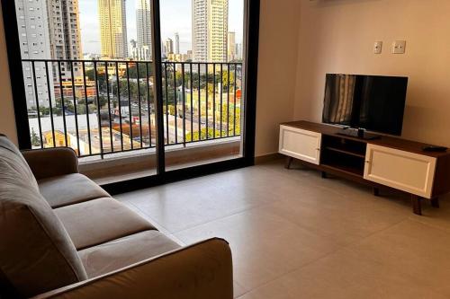 a living room with a couch and a flat screen tv at Apartamento 2 quartos, St Bueno Parque Vaca Brava in Goiânia