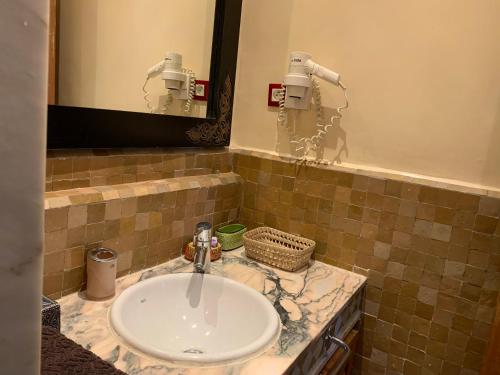 uma casa de banho com um lavatório e um espelho em AbirKech appartement em Marrakech