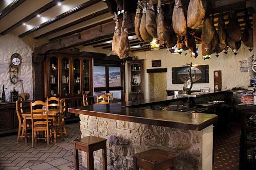 a bar in a restaurant with meat hanging from the ceiling at Hotel Restaurante Seto in Motilla del Palancar