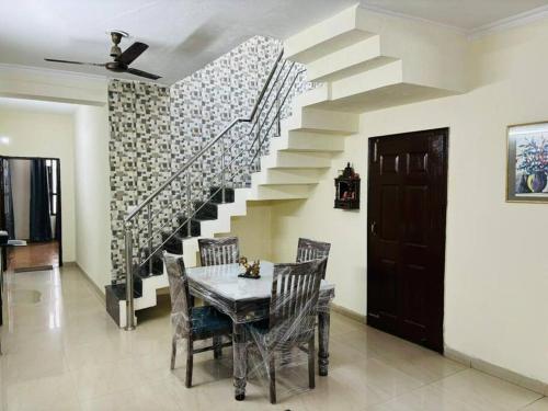 een eetkamer met een tafel en een trap bij Its a spacious penthouse in Chandīgarh