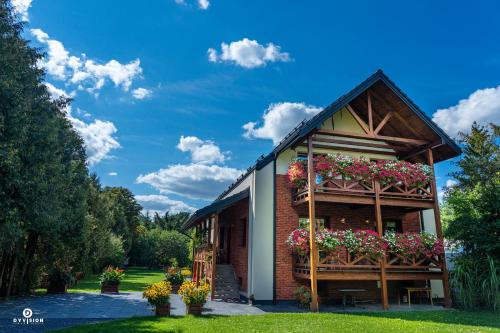 a house with flower boxes on the side of it at Zarębisko - noclegi całoroczne in Zwierzyniec