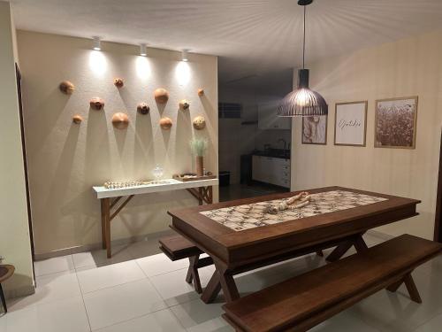 Habitación con mesa, banco y pared con bolas. en Casa Recanto dos Guaiamuns - Carneiros PE en Sirinhaém