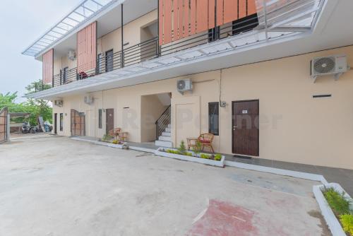 an empty parking lot in front of a building at Rumah Panda Guesthouse RedPartner in Tangkil