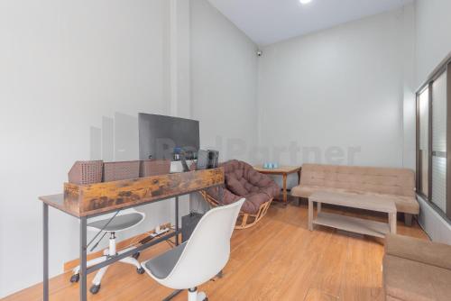 a living room with a couch and a table and chairs at Rumah Panda Guesthouse RedPartner in Tangkil
