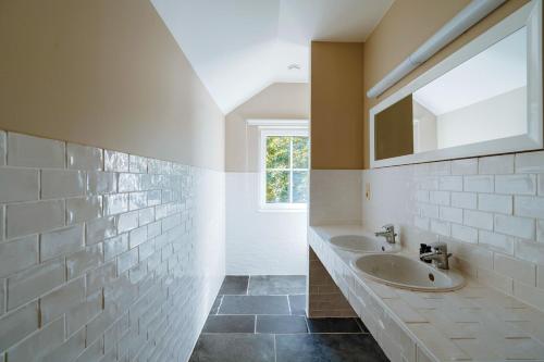 a bathroom with two sinks and a mirror at Le Brocard in Durbuy