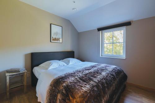 a bedroom with a large bed and a window at Le Brocard in Durbuy