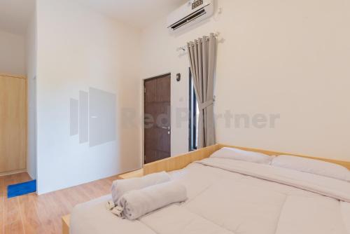 a white bedroom with a large bed in it at Rumah Panda Guesthouse RedPartner in Tangkil