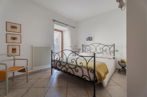 a bedroom with a bed and a table and a chair at Pietra Rara Apartments in Pietramurata