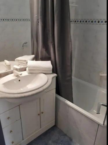 une salle de bain blanche avec un lavabo et une douche dans l'établissement Le Port Dauphin : Vue bateaux; piscine; Cap d'Agde, au Cap d'Agde