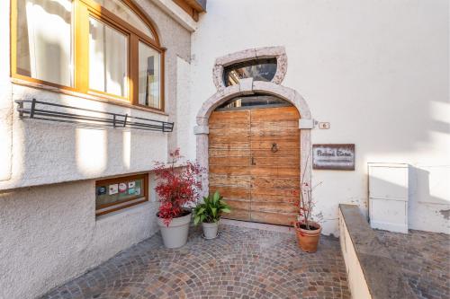 a wooden door on a building with potted plants at Pietra Rara Apartments in Pietramurata