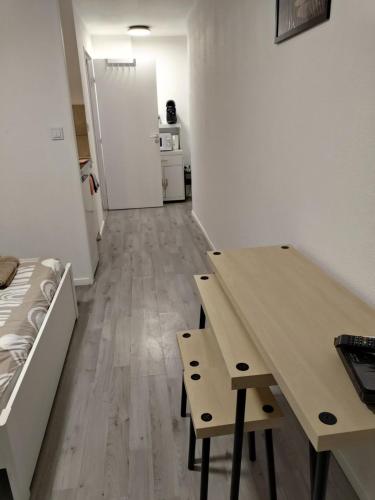 Cette chambre comprend un bureau, une table et un réfrigérateur. dans l'établissement Studio au centre de la Part Dieu, à Lyon