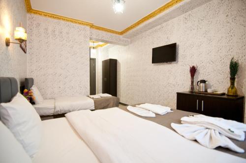 a hotel room with three beds and a tv at Golden Horn Park Hotel in Istanbul