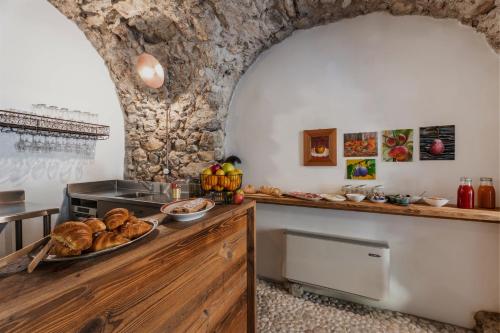 a kitchen with a table with a plate of bread at Pietra Rara Apartments in Pietramurata
